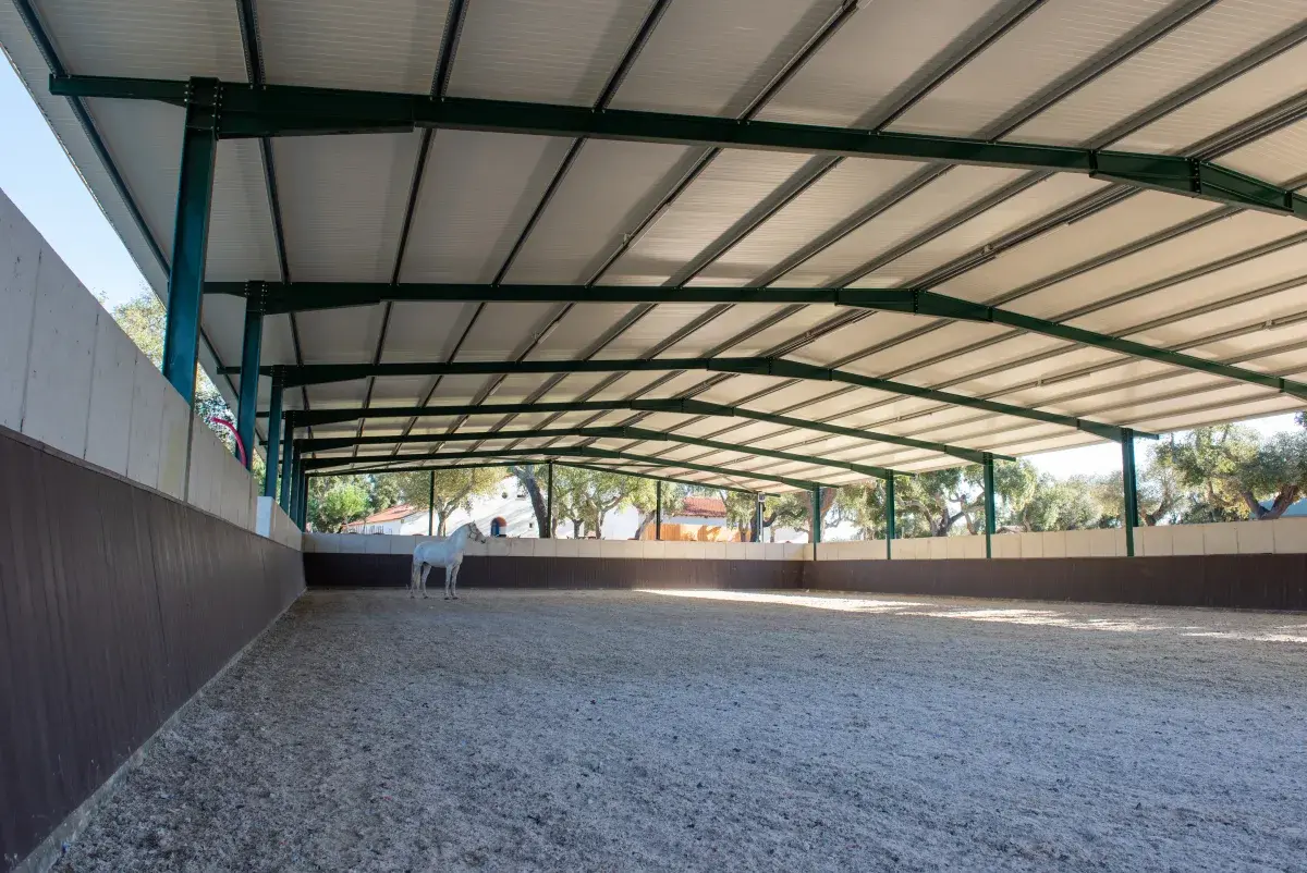 Arena coberta da coudelaria, com piso de areia